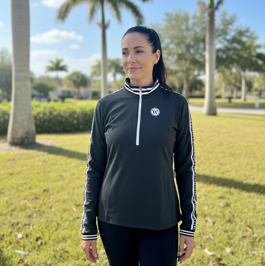 woman wearing black Wellington International Novella Mid-Weight Quarter Zip Jacket outside in florida