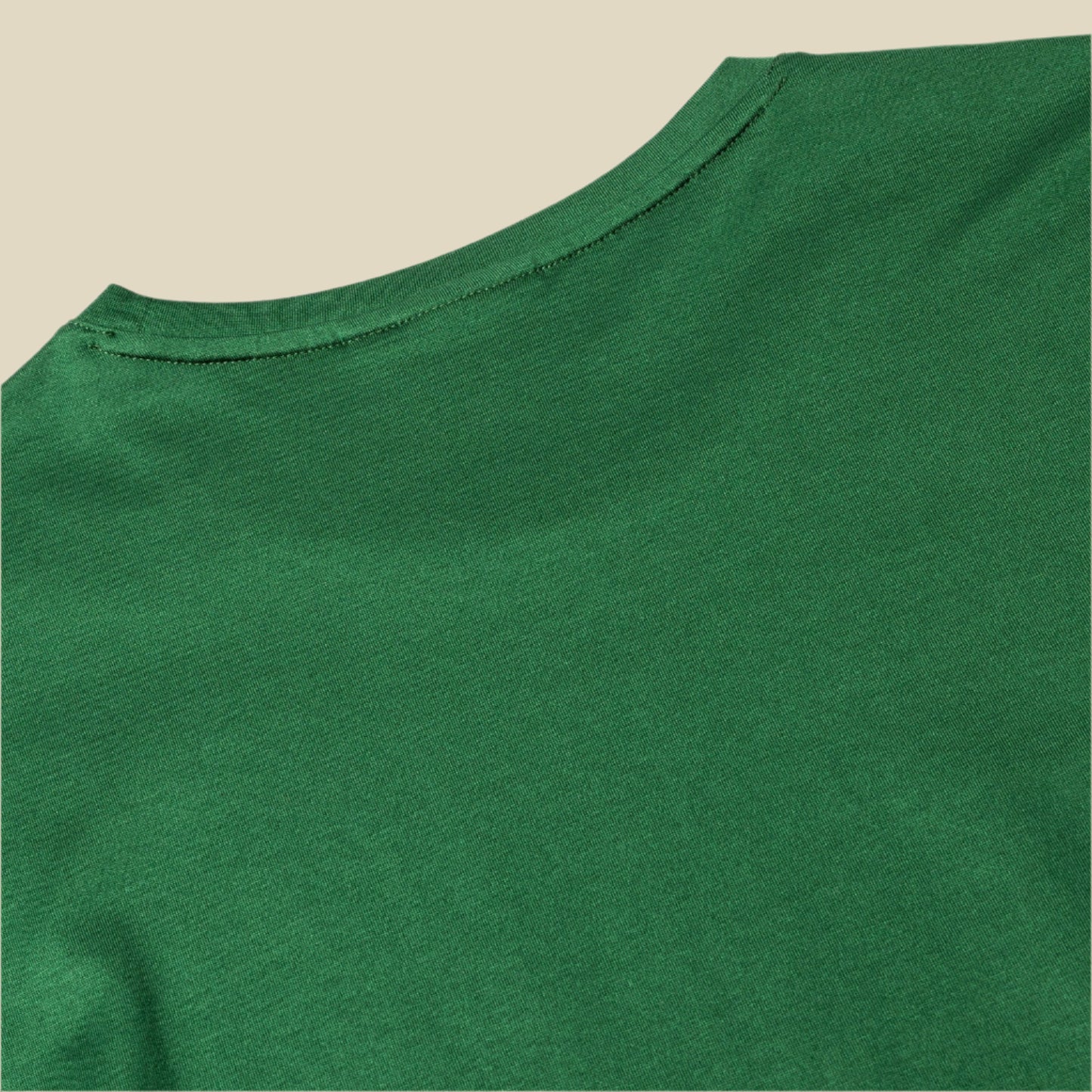 Close-up of a green t-shirt with a plain background