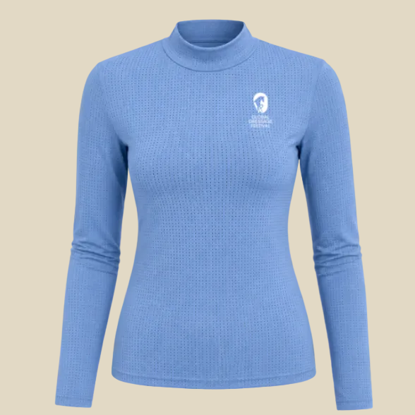 A light blue long-sleeve mock neck shirt with a textured waffle knit pattern and a small white chest graphic, shown on a solid tan background.