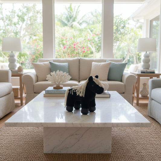 A small black plush toy horse with a cream-colored yarn mane and tail.
