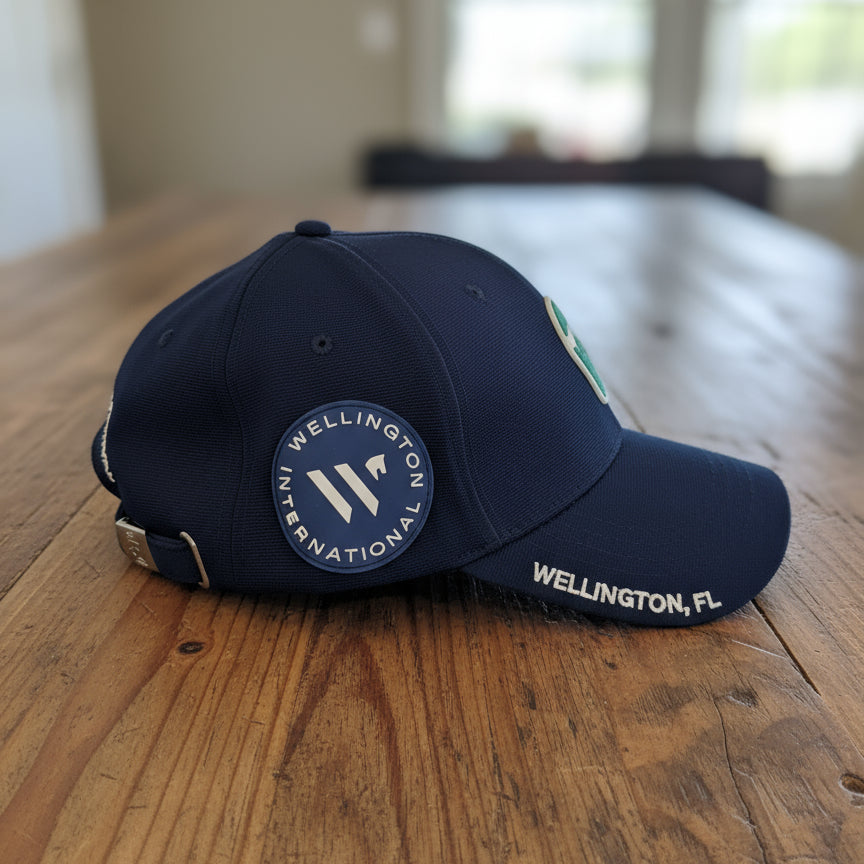 Navy blue WEF hat side view of Wellington International branding on table