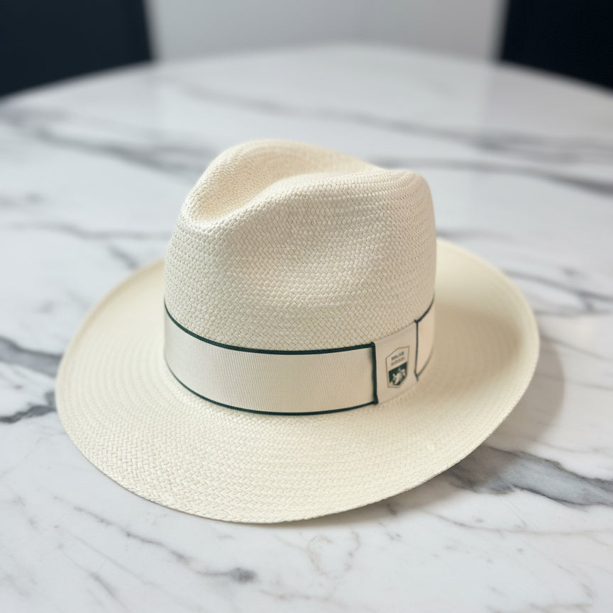 straw rolex series equestrian panama hat on a marble table