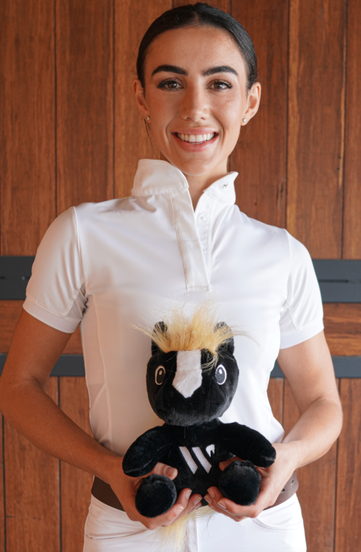 Woman holding a stuffed toy in front of a wooden background
